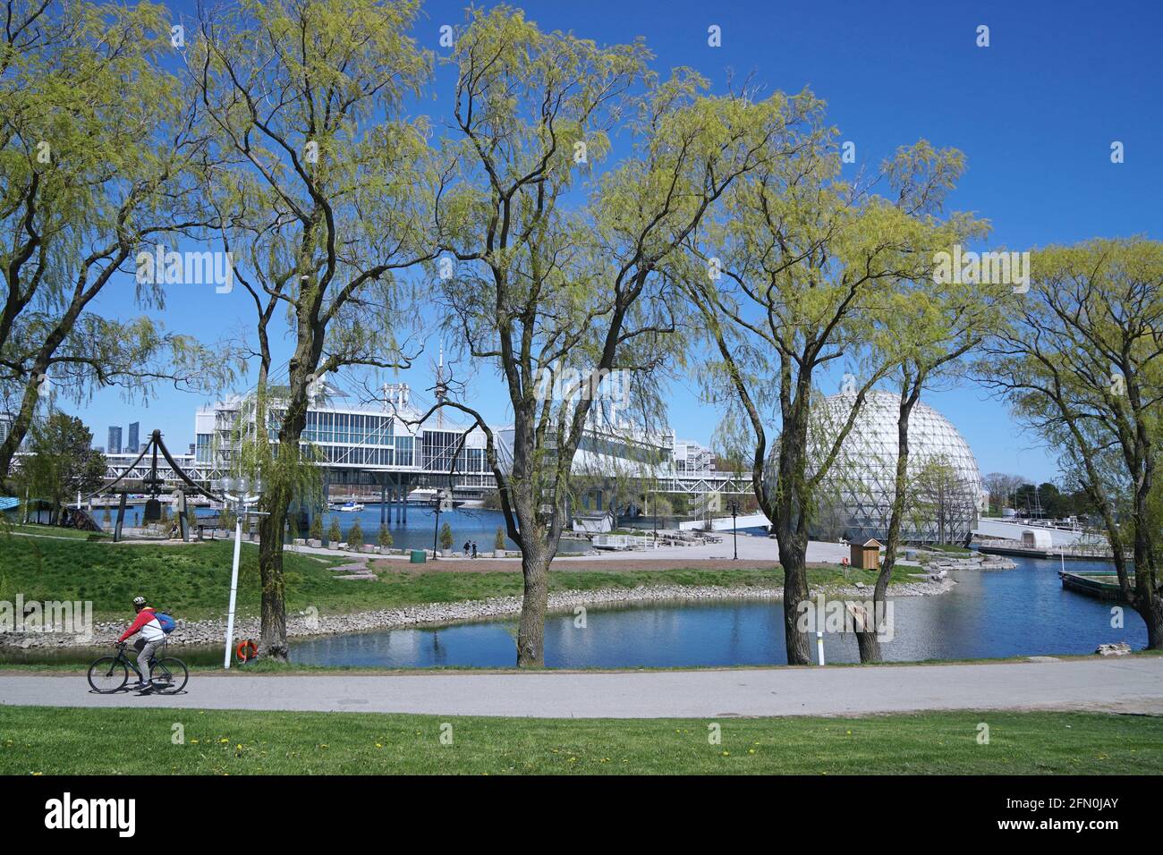 Toronto, Canada - 12 maggio 2021: Parco sul lungomare di Toronto chiamato Ontario Place, con sentieri per passeggiate e bicicletta e gli edifici espositivi accanto a un ritardo Foto Stock