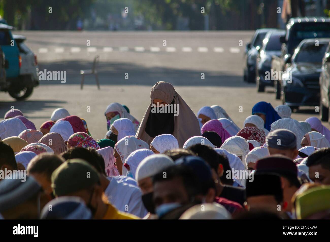 PADANG, INDONESIA, 13 maggio 2021. Milioni di musulmani in Indonesia, nella città di Padang, nella provincia di Sumatra occidentale continuano a fare preghiere per l'Eid sul campo e ad attuare protocolli sanitari mantenendo la loro distanza, anche se il governo ha proibito alle persone di tenere preghiere per l'Eid in congregazione nelle moschee o sul campo. Kariadil Harefa/Alamy Live News - Foto Stock