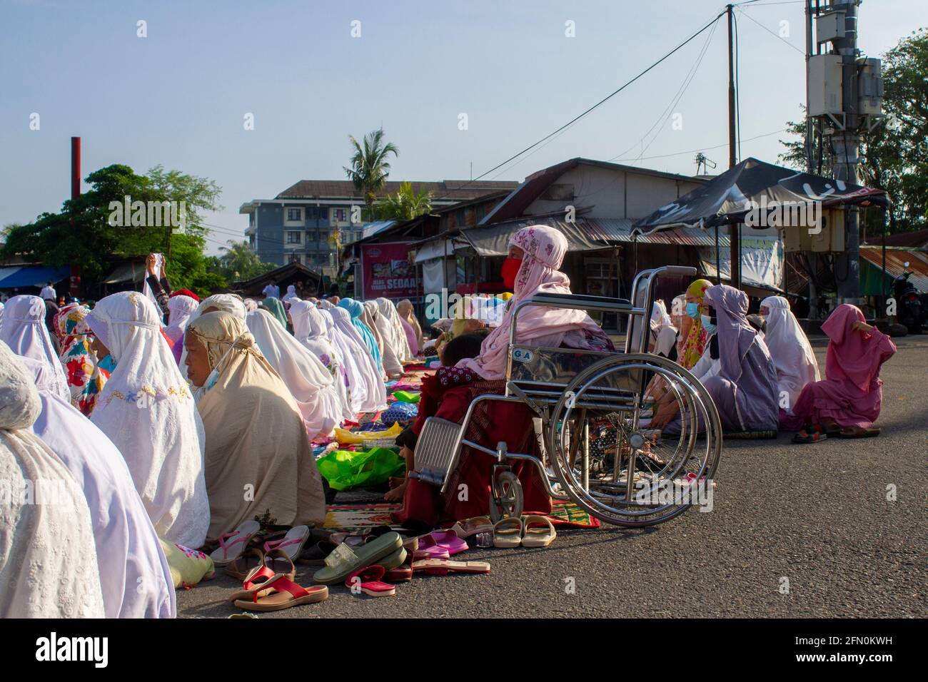 PADANG, INDONESIA, 13 maggio 2021. Milioni di musulmani in Indonesia, nella città di Padang, nella provincia di Sumatra occidentale continuano a fare preghiere per l'Eid sul campo e ad attuare protocolli sanitari mantenendo la loro distanza, anche se il governo ha proibito alle persone di tenere preghiere per l'Eid in congregazione nelle moschee o sul campo. Kariadil Harefa/Alamy Live News - Foto Stock