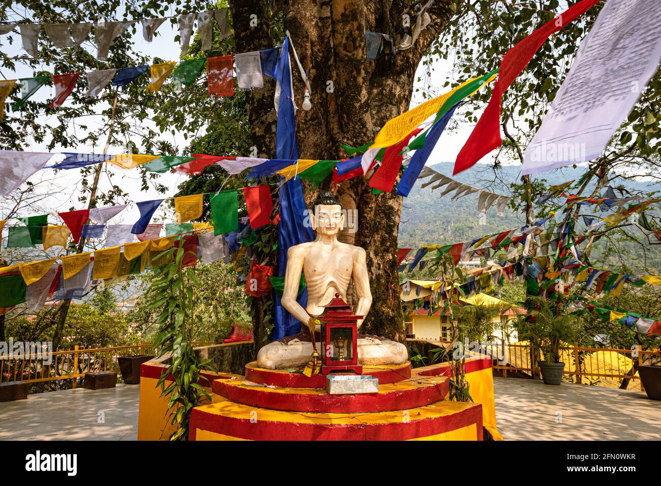 buddha seduto in posizione di meditazione con bandiere religiose al giorno da angolo piatto al monastero di itanagar arunachal pradesh india. Foto Stock