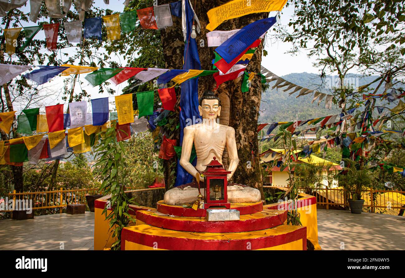 buddha seduto in posizione di meditazione con bandiere religiose al giorno da angolo piatto al monastero di itanagar arunachal pradesh india. Foto Stock