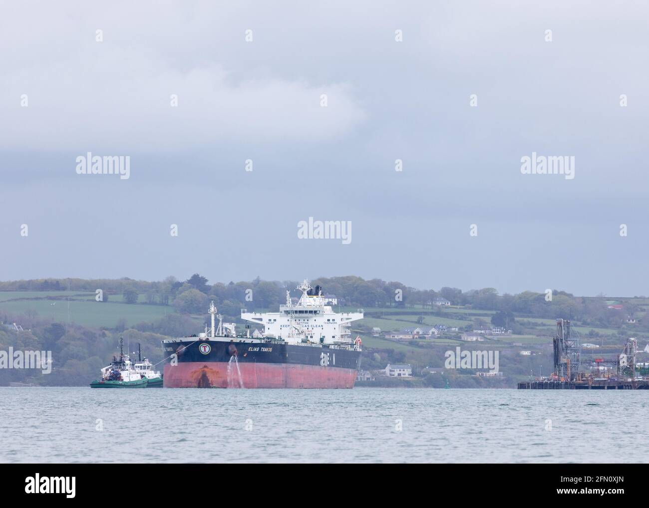 WhiteGate, Cork, Irlanda. 12 maggio 2021. La petroliera Elias Tsakos è assistita dai rimorchiatori Titan e Alex mentre si allontana lentamente dal molo e si allontana dall'arour sulla sua strada per Scapa Flow a WhiteGate, Co. Cork, Irlanda. - credito; David Creedon / Alamy Live News Foto Stock