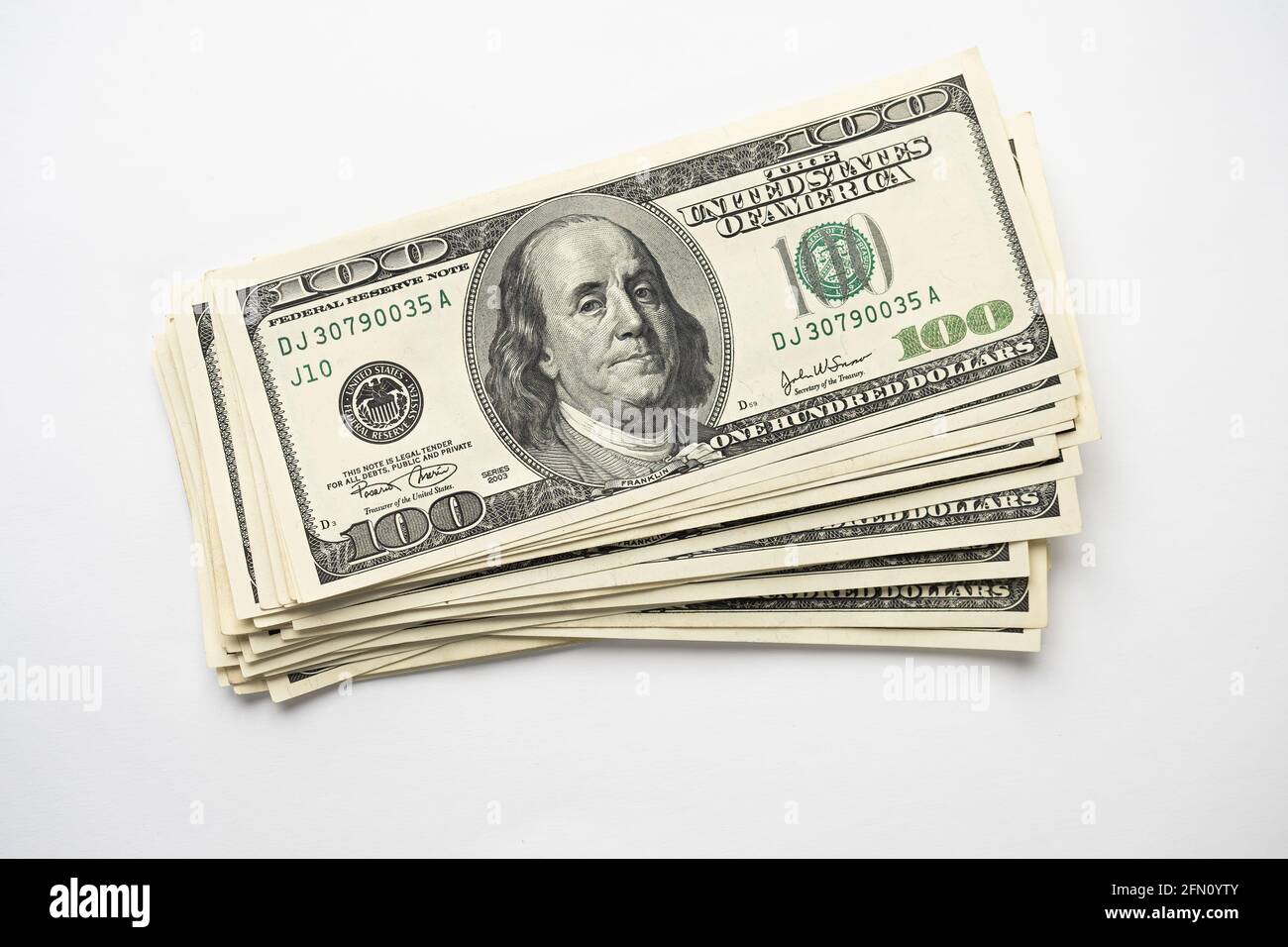 Un mucchio di denaro di cento banconote americane impilate con il ritratto del presidente Franklin su sfondo bianco. Contanti di cento fatture del dollaro, curre di soldi della carta Foto Stock