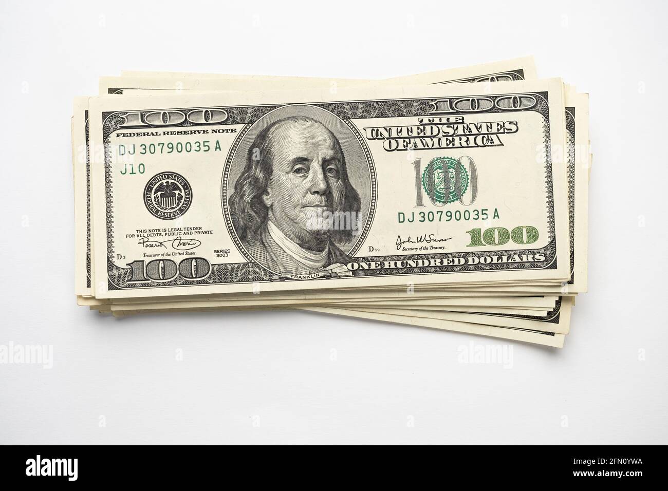 Un mucchio di denaro di cento banconote americane impilate con il ritratto del presidente Franklin su sfondo bianco. Contanti di cento fatture del dollaro, curre di soldi della carta Foto Stock