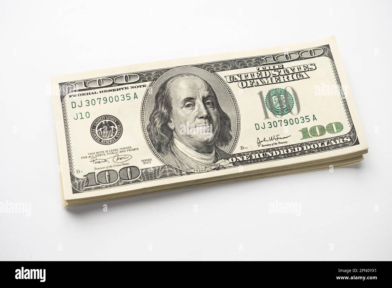 Un mucchio di denaro di cento banconote americane impilate con il ritratto del presidente Franklin su sfondo bianco. Contanti di cento fatture del dollaro, curre di soldi della carta Foto Stock