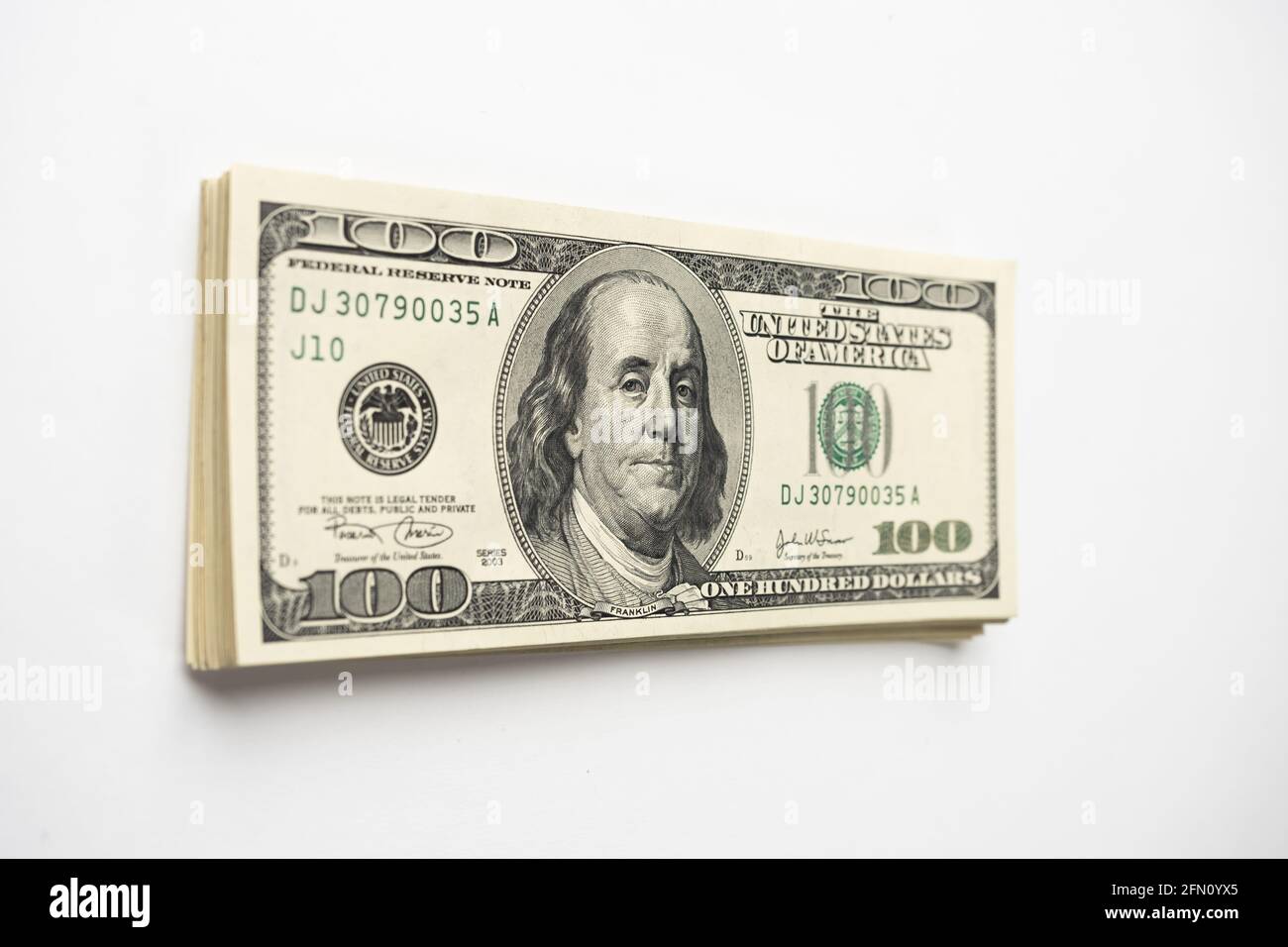 Un mucchio di denaro di cento banconote americane impilate con il ritratto del presidente Franklin su sfondo bianco. Contanti di cento fatture del dollaro, curre di soldi della carta Foto Stock