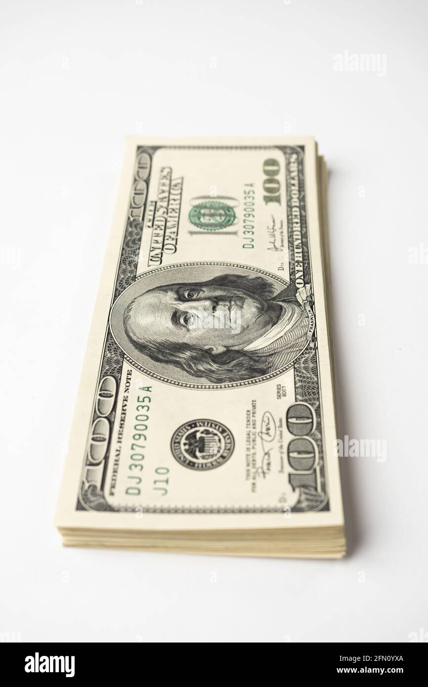 Un mucchio di denaro di cento banconote americane impilate con il ritratto del presidente Franklin su sfondo bianco. Contanti di cento fatture del dollaro, curre di soldi della carta Foto Stock