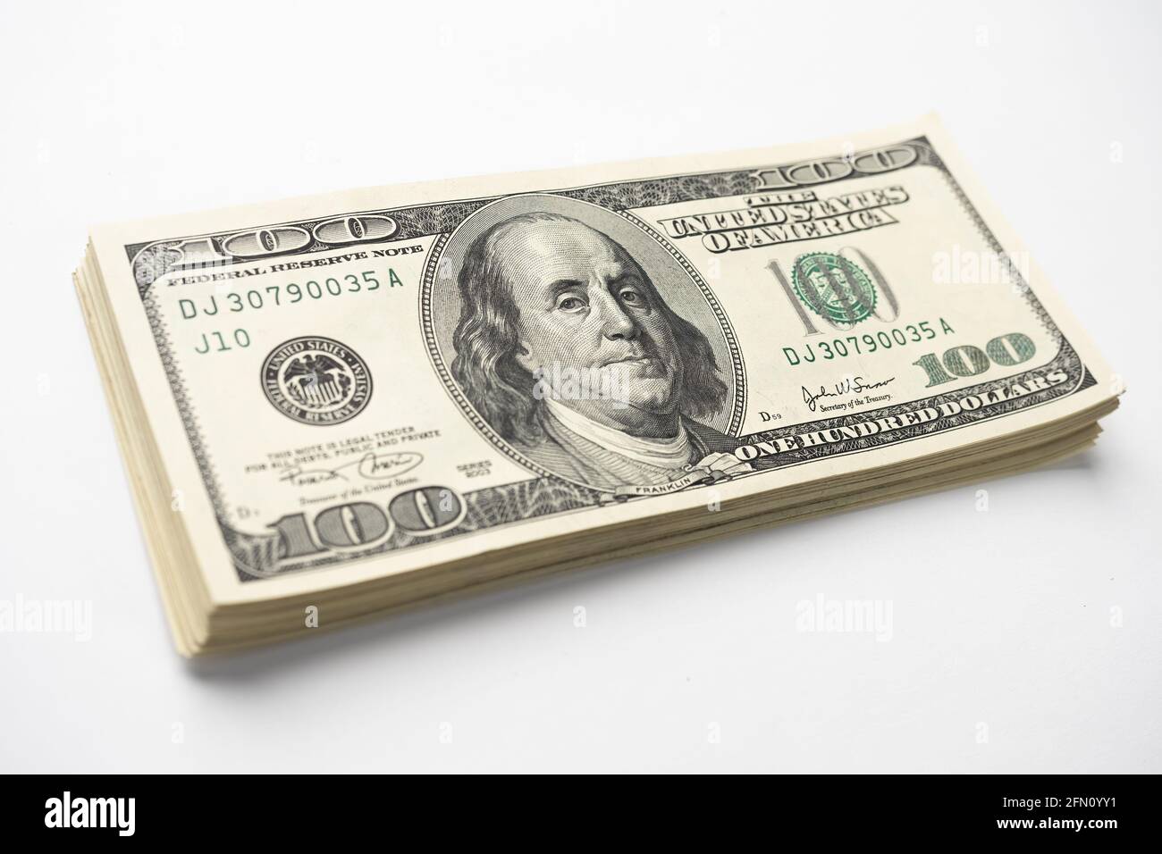 Un mucchio di denaro di cento banconote americane impilate con il ritratto del presidente Franklin su sfondo bianco. Contanti di cento fatture del dollaro, curre di soldi della carta Foto Stock