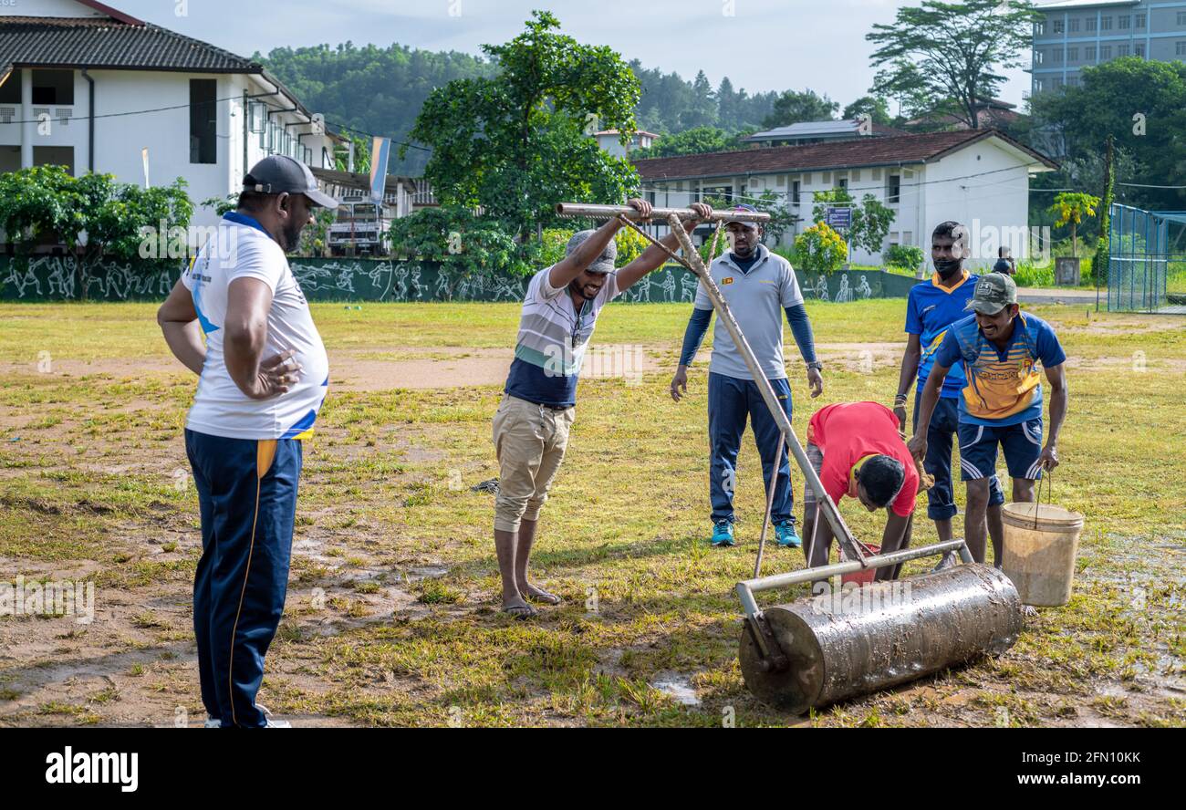 Galle, Sri Lanka - 04 17 2021: Giocatori e staff preparano il campo di cricket e il terreno dopo la pioggia pesante. Rimozione di acqua in eccesso e fango mentre rullo u Foto Stock