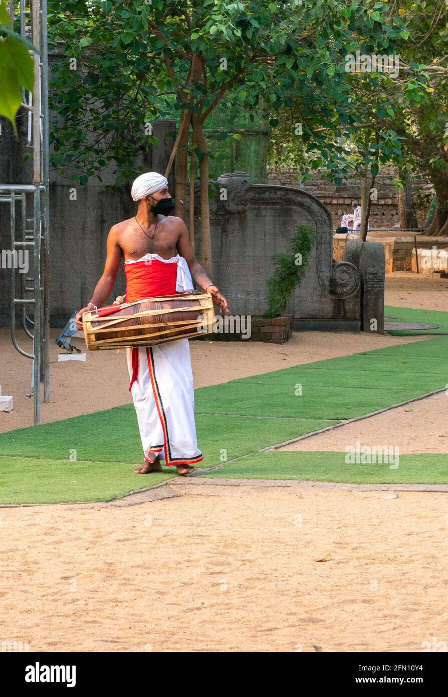 Anuradhapura, Sri Lanka - 03 31 2021: Batterista tradizionale isolato al tempio Jaya Sri Maha Bodhi. Foto Stock