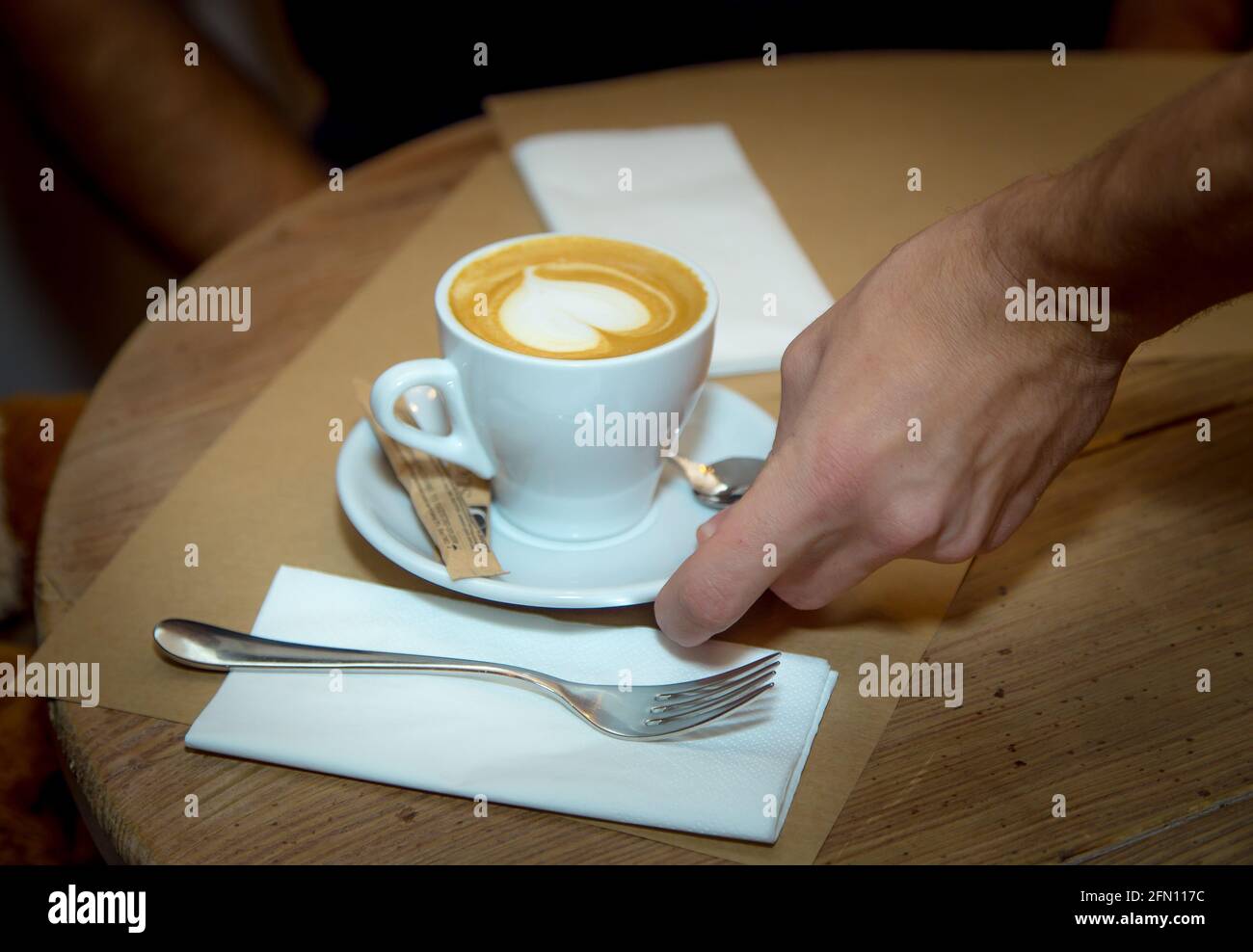 Storie d'amore. Tazza con caffè su un tavolo di legno. C'è un cuore sulla superficie. Foto Stock
