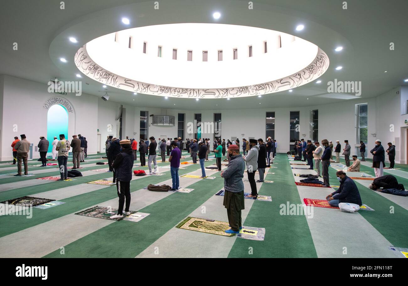 Gli adoratori osservano le distanze sociali durante le preghiere serali di Isha alla Moschea di Baitul Futuh, a Morden, a sud-ovest di Londra, l'ultimo giorno del Ramadan, prima dell'inizio delle celebrazioni di Eid al-Fitr che segnano la fine del mese musulmano di digiuno. Data immagine: Mercoledì 12 maggio 2021. Foto Stock