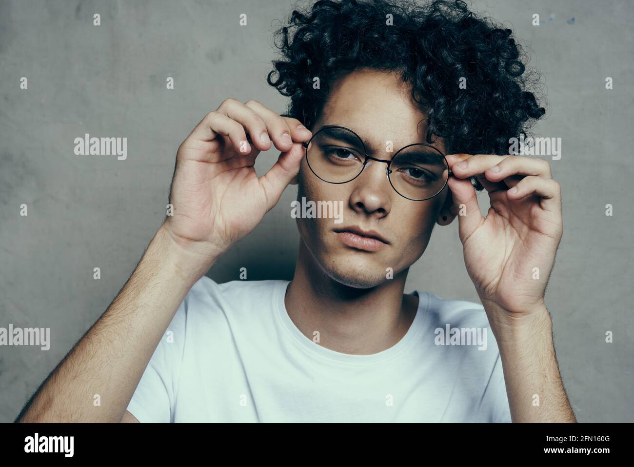 ragazzo con capelli ricci emozioni occhiali di moda primo piano studio Foto  stock - Alamy