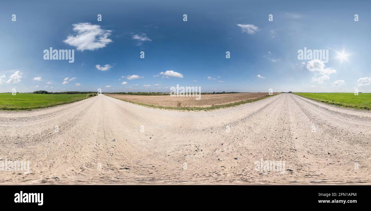 panoramica hdri completamente sferica senza cuciture con angolo di 360 gradi nessun traffico sabbia bianca ghiaia strada tra i campi con chiaro cielo in proje equirettangolare Foto Stock