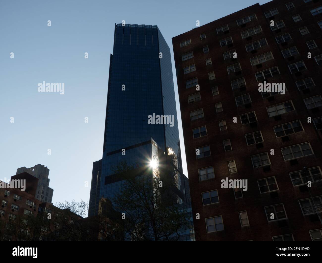 La luce del sole si riflette in una facciata di vetro di un alto edificio Edificio a New York City Foto Stock