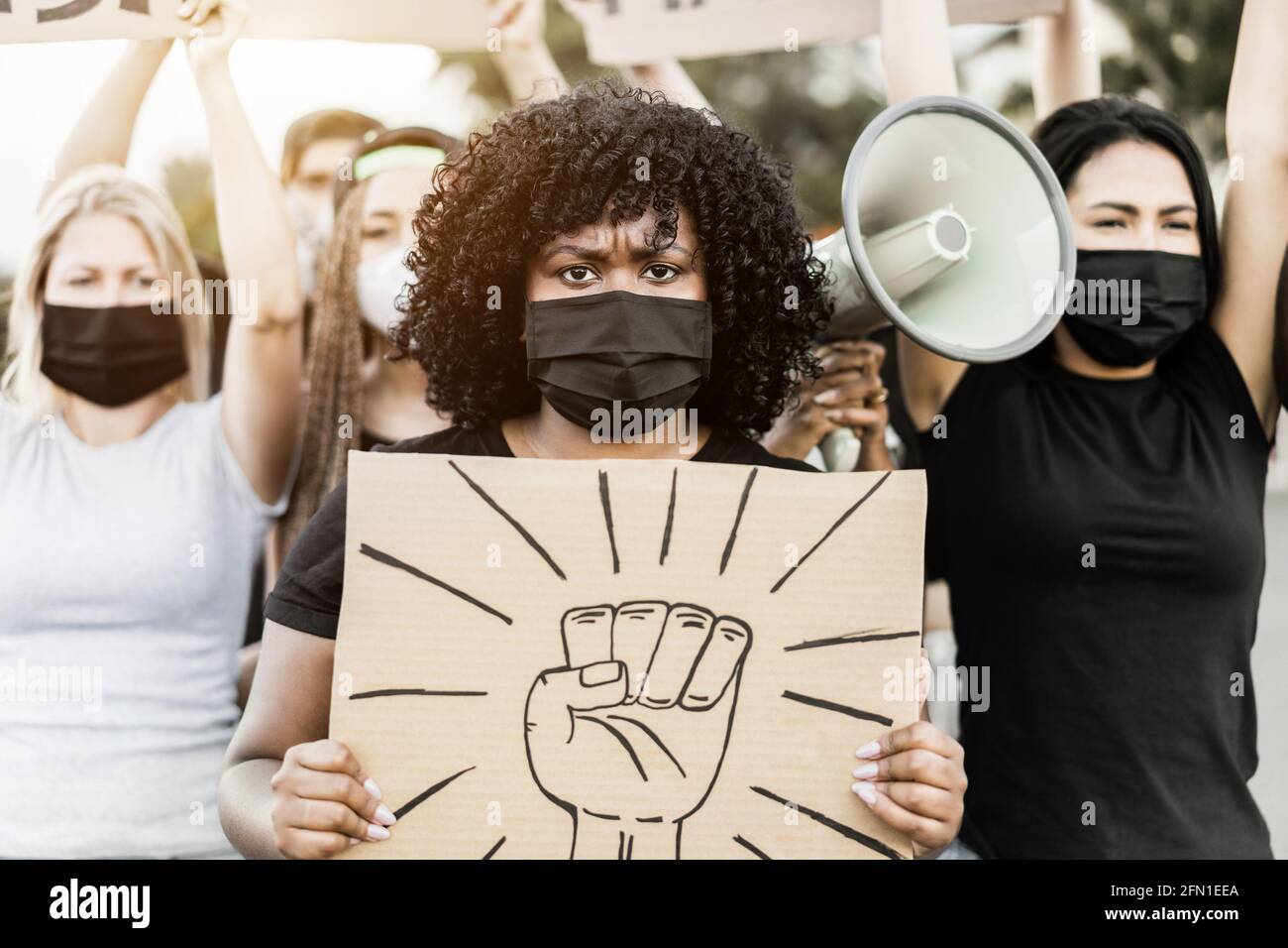Persone di cultura e razze diverse protestano per strada Per pari diritti - Focus sul volto della donna Foto Stock