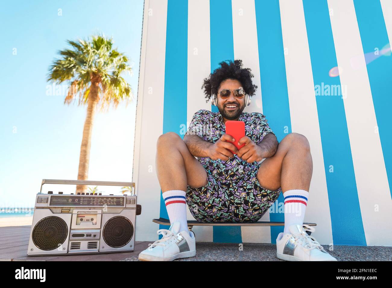 afroamericano uomo musica d'ascolto con stereo boombox vintage all'aperto con spiaggia in background - Estate stile di vita, viaggio e concetto di festa - Focus Foto Stock