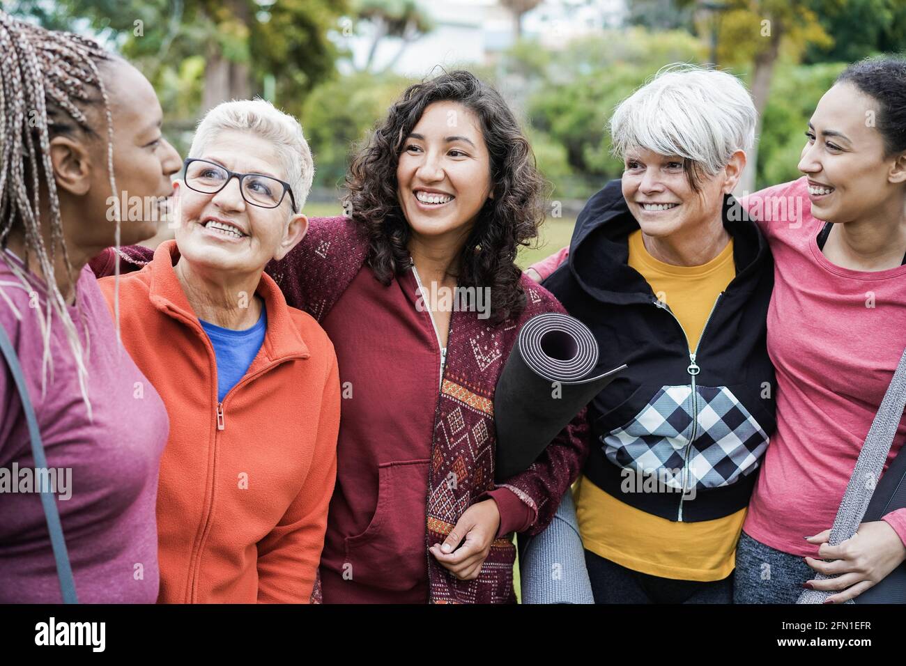 Felici donne multi generazionali che si divertono insieme dopo l'allenamento sportivo Outdoors - fuoco principale sul viso centrale della ragazza Foto Stock