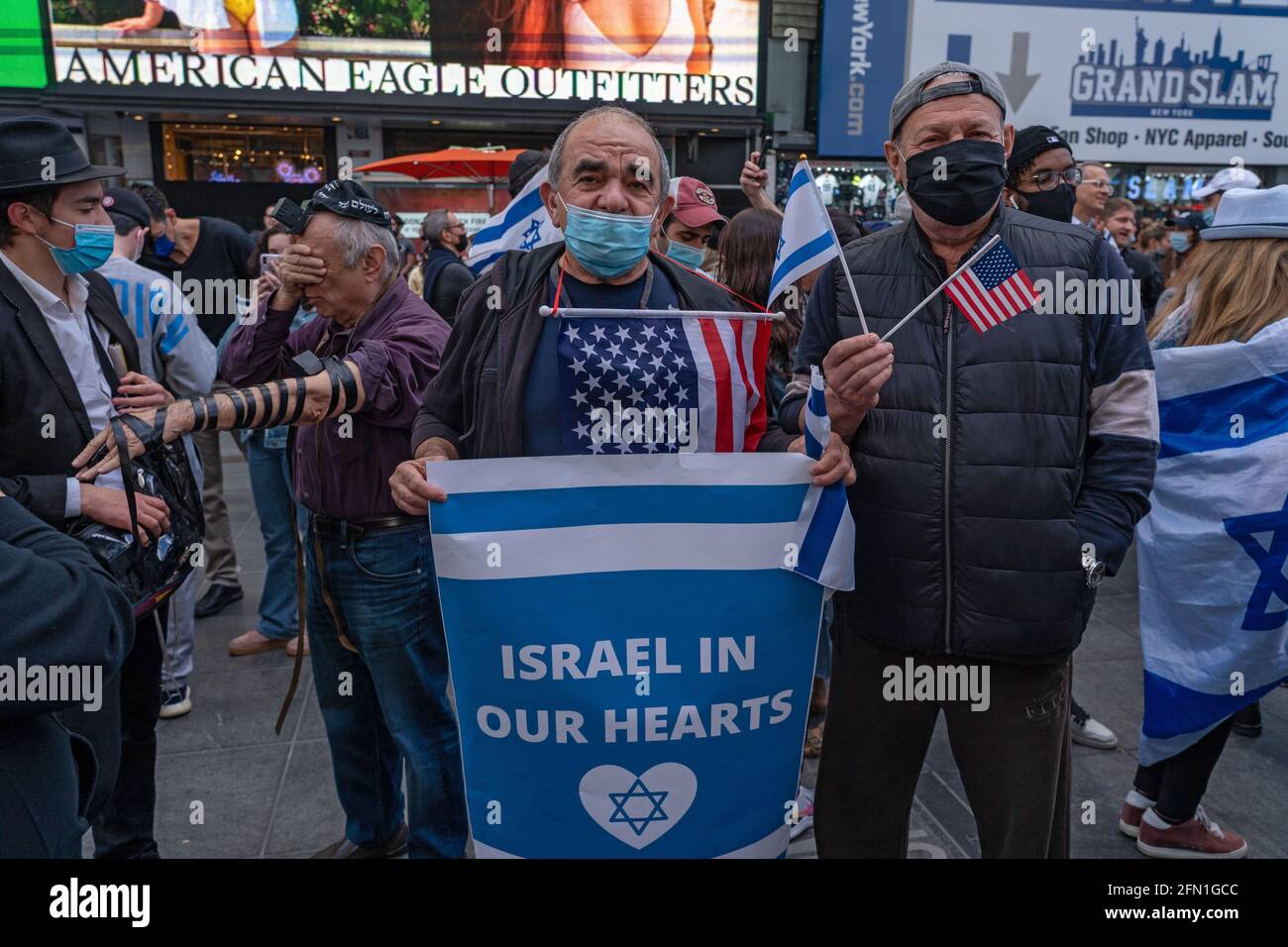 Un sostenitore pro-Israele detiene bandiere mentre il Consiglio israelo-americano (IAC) e altri gruppi ebrei americani si riuniscono a Times Square in solidarietà con Israele. Migliaia di newyorkesi pro-Israele si sono impacchettati a Times Square all'inizio di questa sera per un raduno in solidarietà con lo stato ebraico tra giorni di fuoco a razzo da Gaza. Il rally è stato organizzato dal Consiglio Israeliano Americano, che ha organizzato manifestazioni simili a Boston, Los Angeles, Atlanta, Austin, Cleveland, Denver, Houston, Irvine, Las Vegas, Orlando, Philadelphia, Redwood City, Seattle, Scottsdale, St. Louis, Walnut Creek, Washington Foto Stock