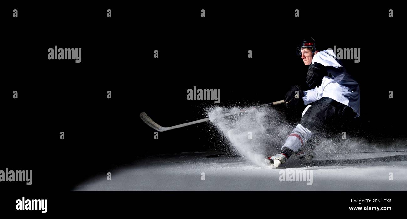 Giocatore di hockey su ghiaccio in azione a calci con bastone. Concetto sportivo professionale Foto Stock