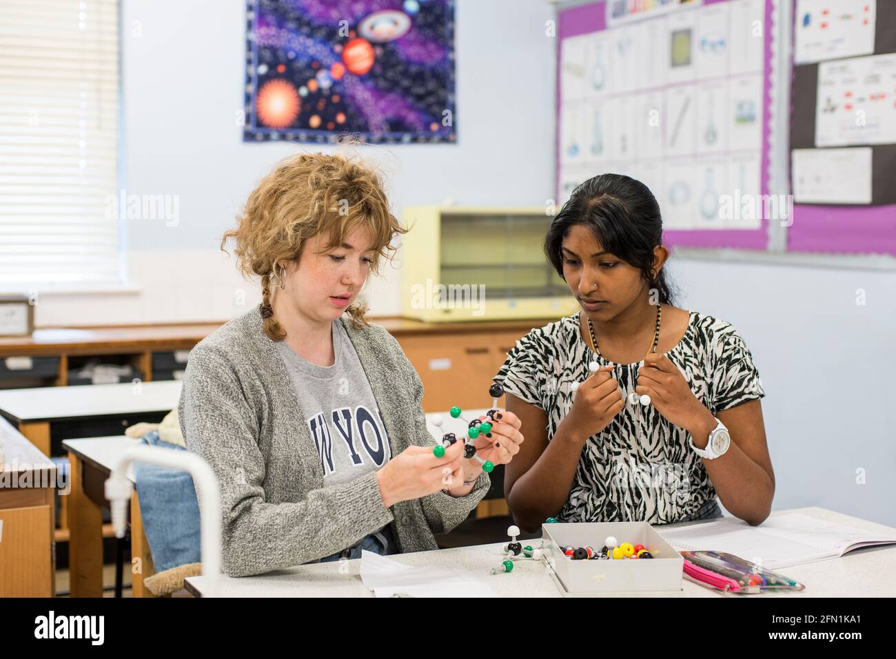 Sesta forma studenti, giovani in istruzione, due adolescenti che collaborano, 2 giovani donne che lavorano con il kit modello molekolare in chimica Foto Stock