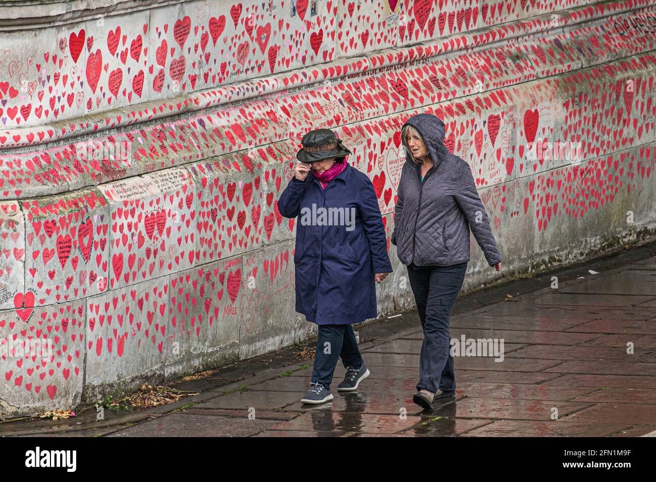 WESTMINSTER LONDRA 13 maggio 2021. I pedoni camminano oltre il muro dei cuori al National Covid Memorial Wall lungo l'argine del Tamigi dedicato alle famiglie in lutto per Justice UK. Il primo ministro Boris Johnson ha annunciato di tenere un’indagine pubblica indipendente che si terrà nel 2022 sulla gestione da parte del governo della pandemia del coronavirus che ha causato 150,000 vittime e di nominare un presidente e dei panelisti. Credit amer Ghazzal/Alamy Live News Foto Stock