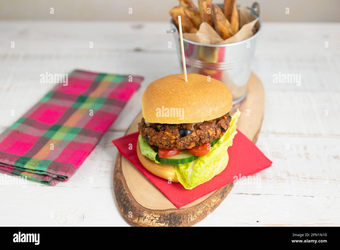 Hamburger vegetariano fatto in casa in un brioche con un lato di chip Foto Stock
