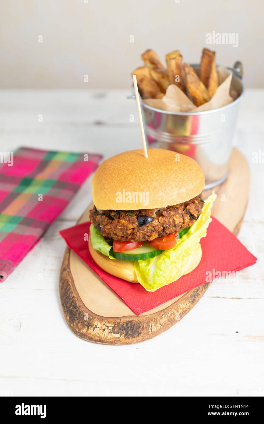 Hamburger vegetariano fatto in casa in un brioche con un lato di chip Foto Stock