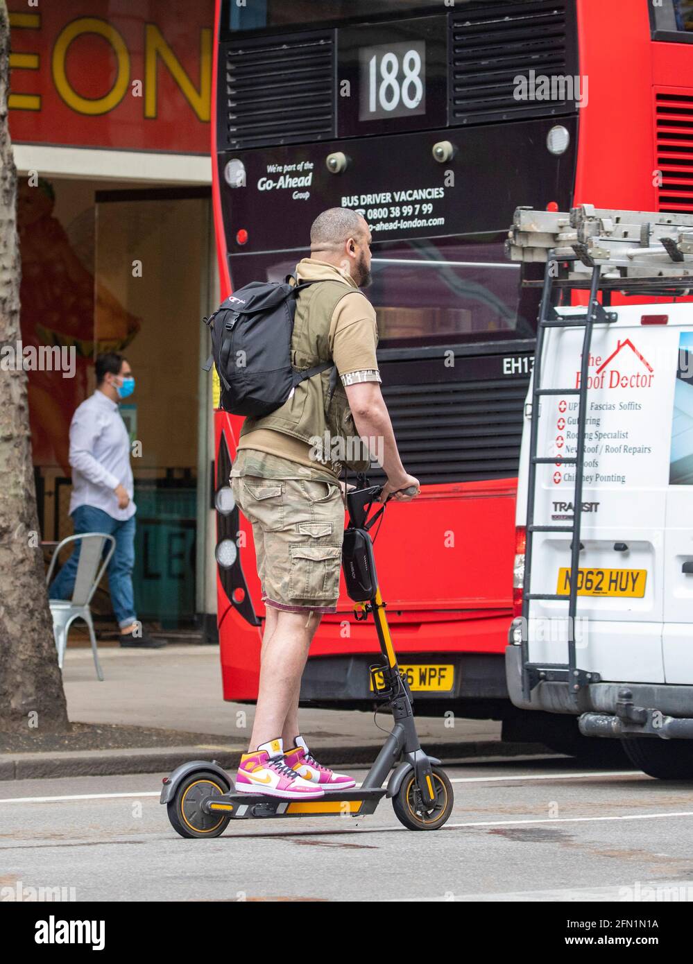 uomo su scooter elettrico Foto Stock