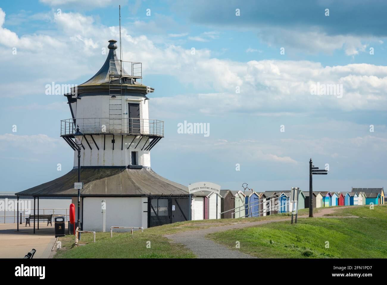 Faro Harwich, vista del C18 Low Lighthouse edificio (ora un museo marittimo) con capanne sulla spiaggia di fronte Harwich Green, Essex, Inghilterra, Regno Unito Foto Stock