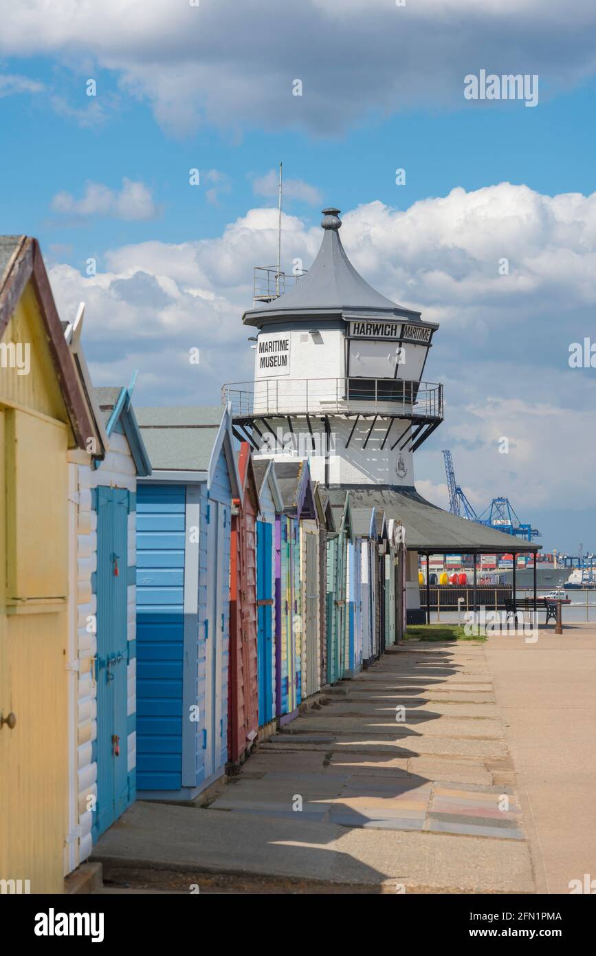 Harwich Beach, vista del C18 Low Lighthouse edificio (ora un museo marittimo) con capanne sulla spiaggia di fronte Harwich Beach, Essex, Inghilterra, Regno Unito Foto Stock