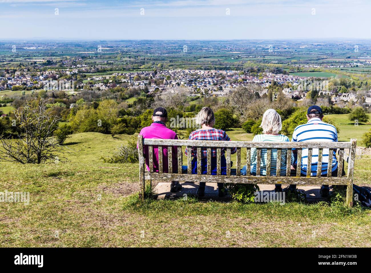 I quattro escursionisti godono della vista sulla città di Broadway del Worcestershire e la vale di Evesham dal sentiero a lunga distanza della Cotswold Way. Foto Stock