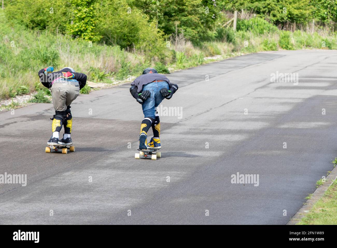 Skateboarders in una posizione aerodinamica che scende in discesa Foto Stock