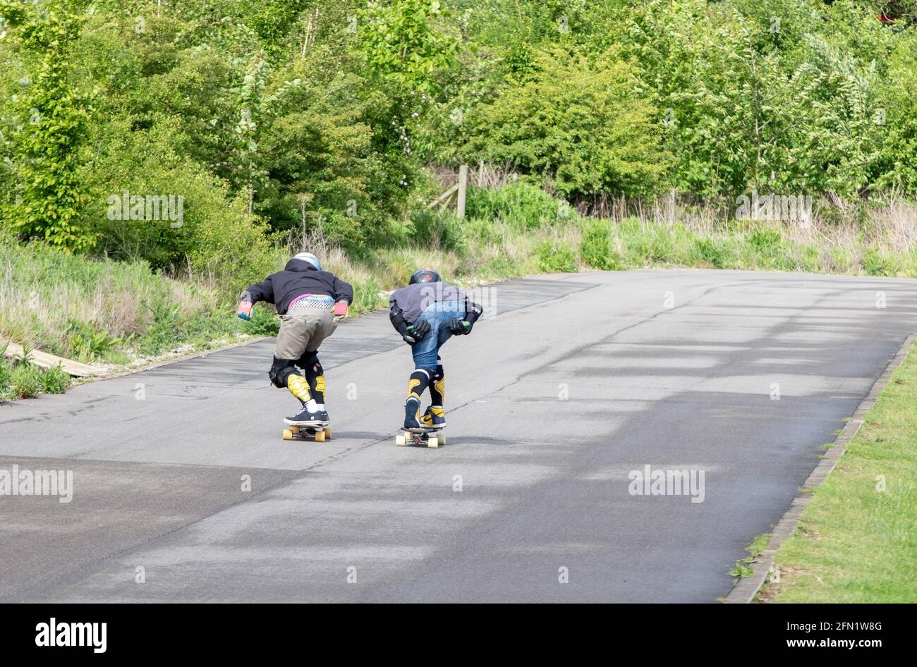 Skateboarders in una posizione aerodinamica che scende in discesa Foto Stock