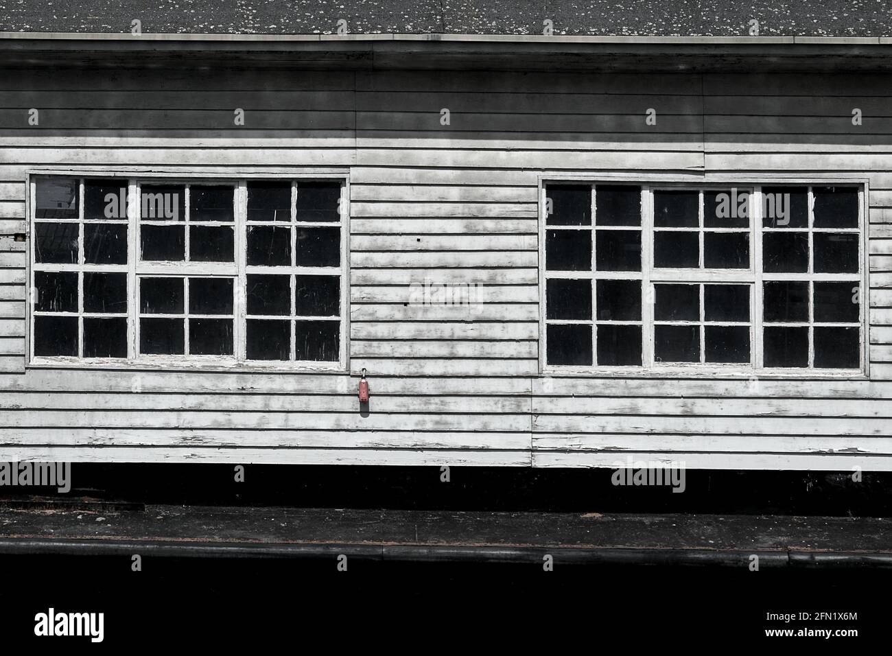 Finestra nell'esterno stagionato delle pareti in legno di un vecchio cottage, minimalista monocromatico Foto Stock
