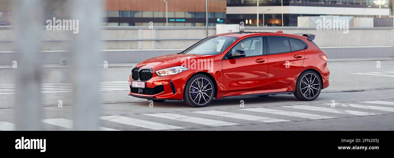 Red BMW M135i nel parcheggio di fronte agli uffici. Modello F40, prodotto a partire dal 2019. motore 306 cv, accelerazione 0-100 km / h: 4.8 s. Kat Foto Stock