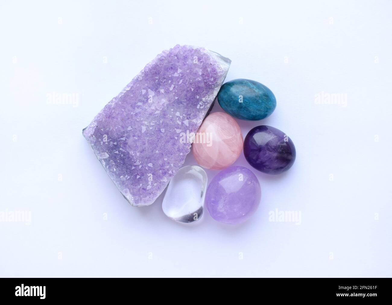 Gemme e cristalli di vari colori. Ametystdruze, quarzo rosa, apatite, cristallo di roccia su sfondo bianco. Foto Stock