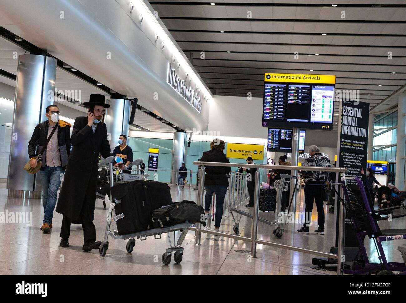 Londra, Regno Unito. 13 maggio 2021. I passeggeri che arrivano al Terminal 2 di Heathrow oggi. Dal 17 maggio entreranno in vigore nuove regole di viaggio. I giorni festivi possono riprendere. Ci sarà un sistema di "semafori" con paesi classificati come Verde, Ambra e Rosso. British Airways ha sospeso i voli da e per Israele a causa della situazione attuale. Credit: Mark Thomas/Alamy Live News Foto Stock