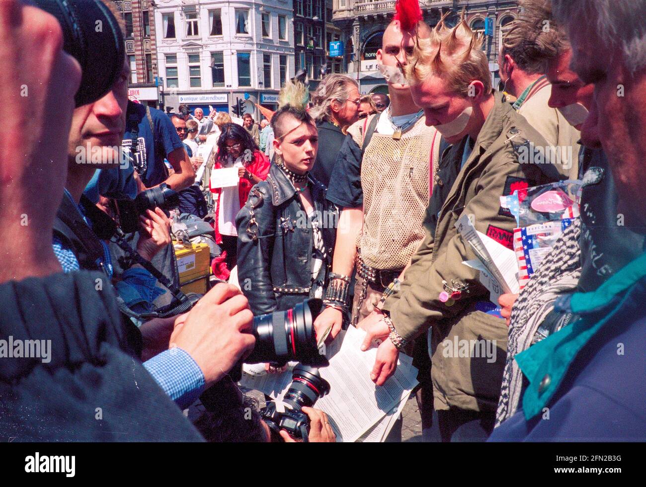 Dimostrazione storica dei punk in piazza Dam di Amsterdam all'inizio del 90s, con la polizia e la stampa con manifestanti con la bocca chiusa. Foto Stock
