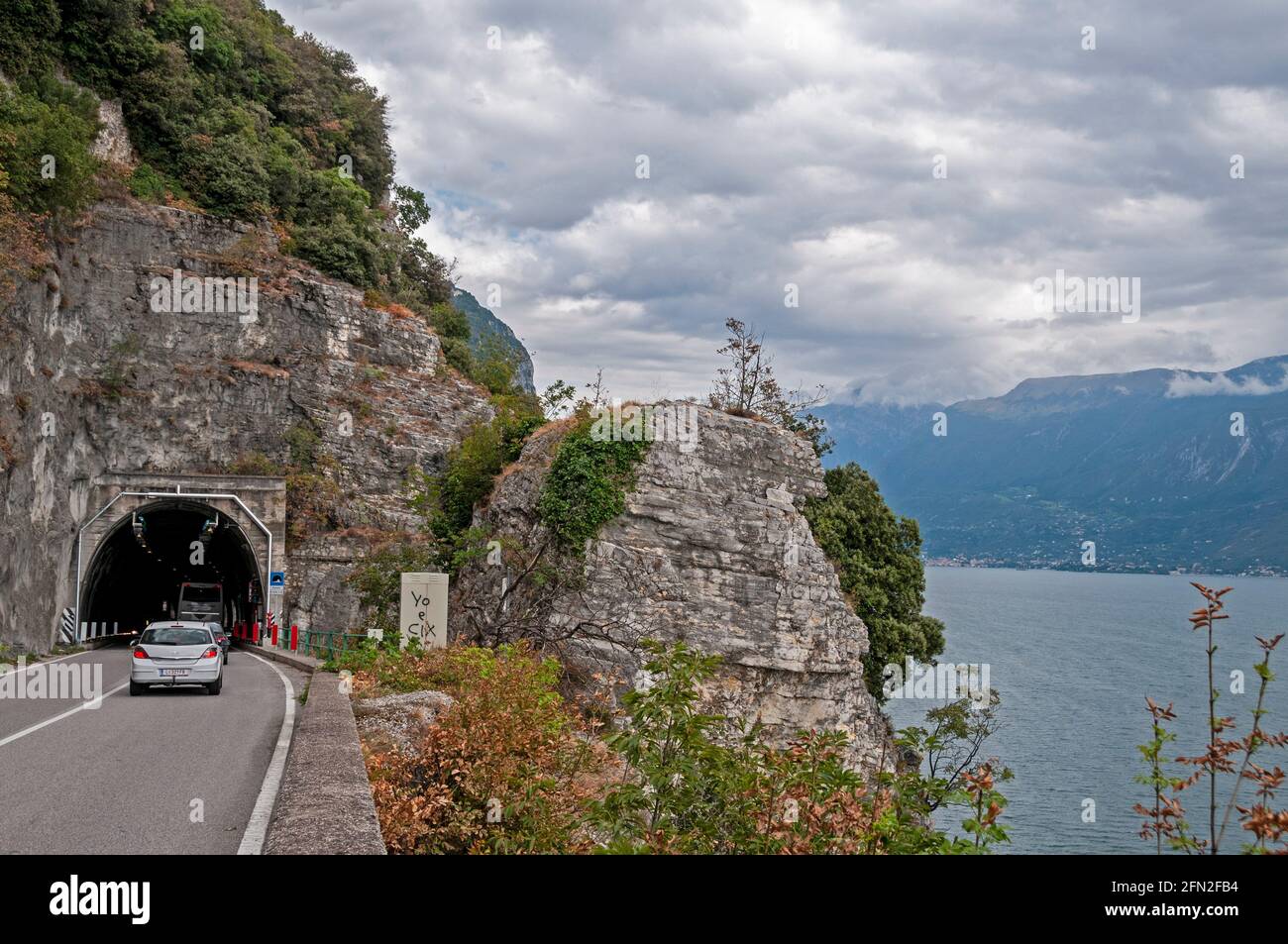 Uno dei tunnel a traffico stradale stretto, che si snoda parallelamente lungo il versante montagnoso occidentale del Lago di Garda, nel nord Italia. Foto Stock