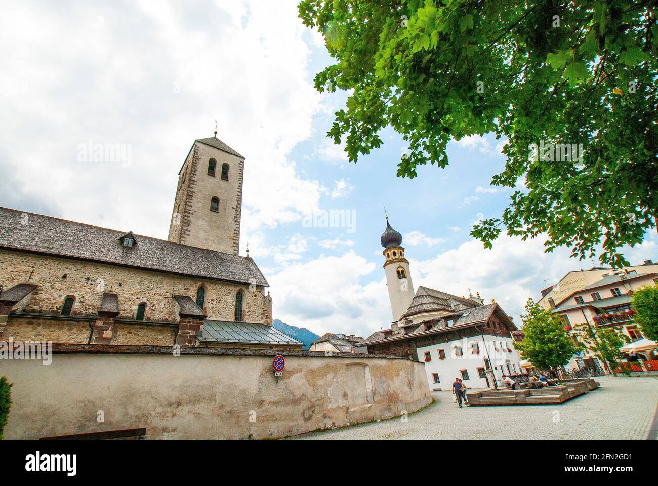 Il campanile della Chiesa di San Michele e la parete laterale della Collegiata di San Candido, San Candido, Dolomiti, Italia, Val Pusteria Foto Stock