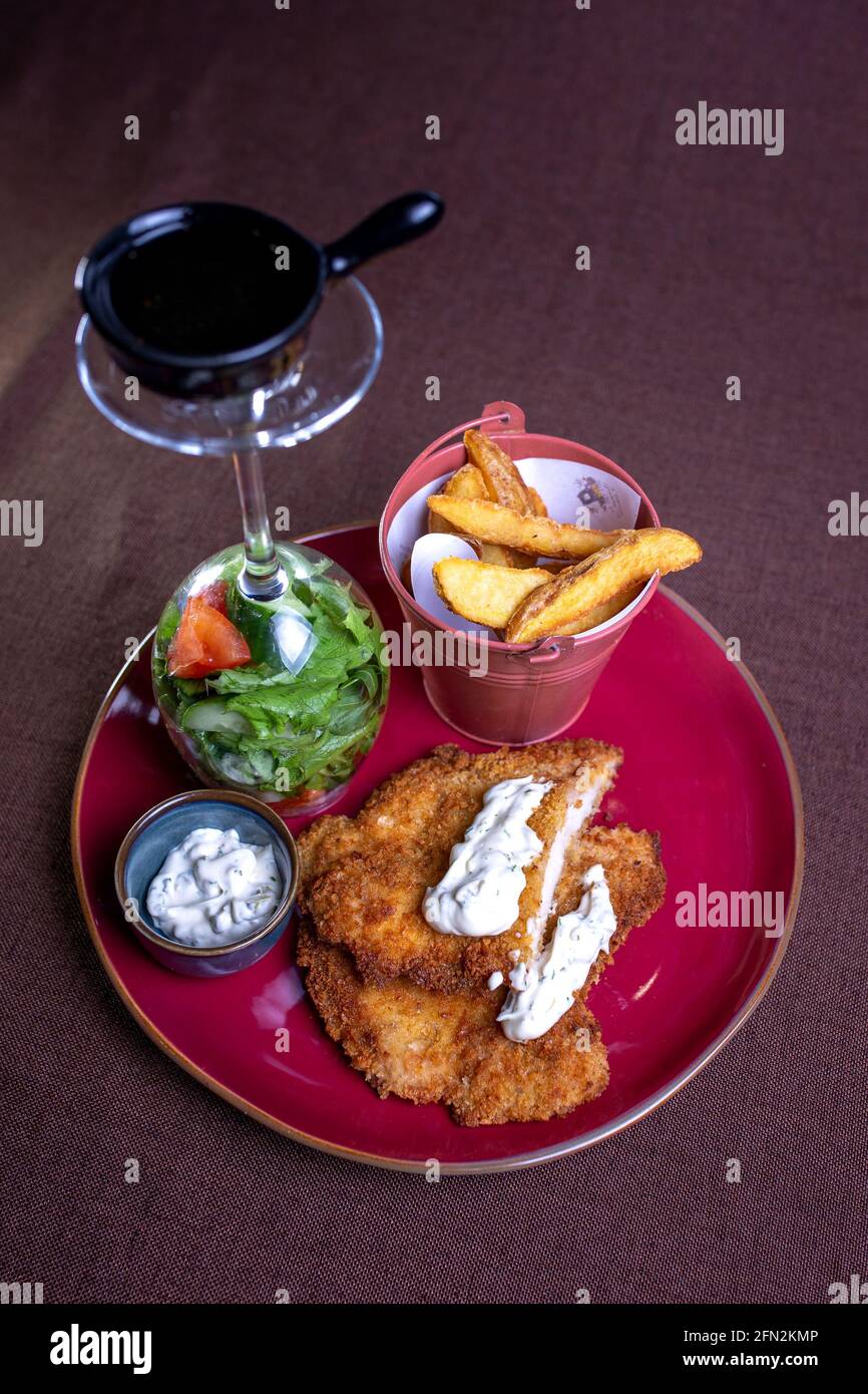 bocconcini di pollo con salsa e patate. Il servizio del piatto nella caffetteria è bellissimo. Foto Stock