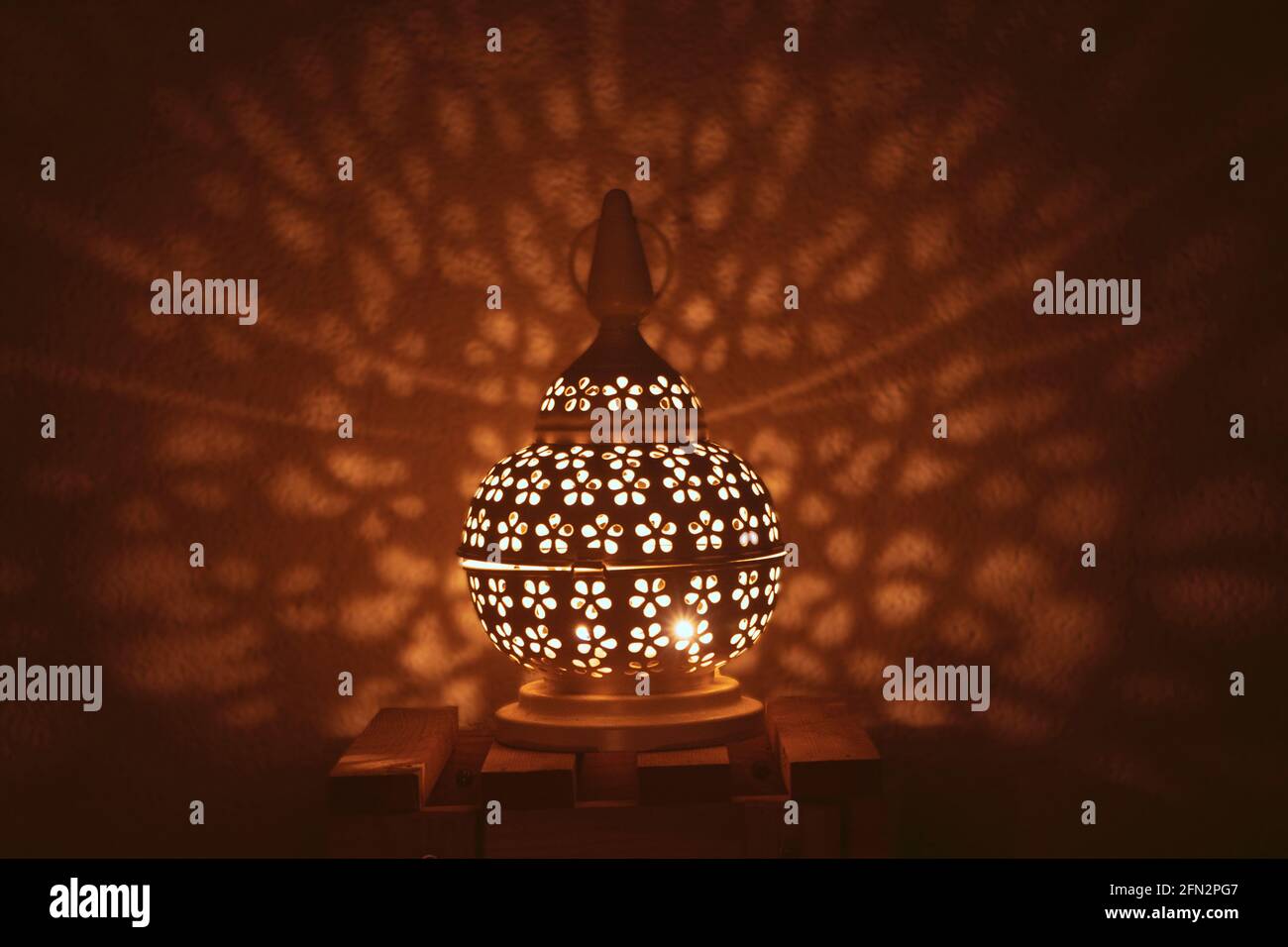 Lanterna araba ornamentale con candele accese di notte e scintillanti luci dorate del bokeh. Biglietto d'auguri natalizio, Foto Stock