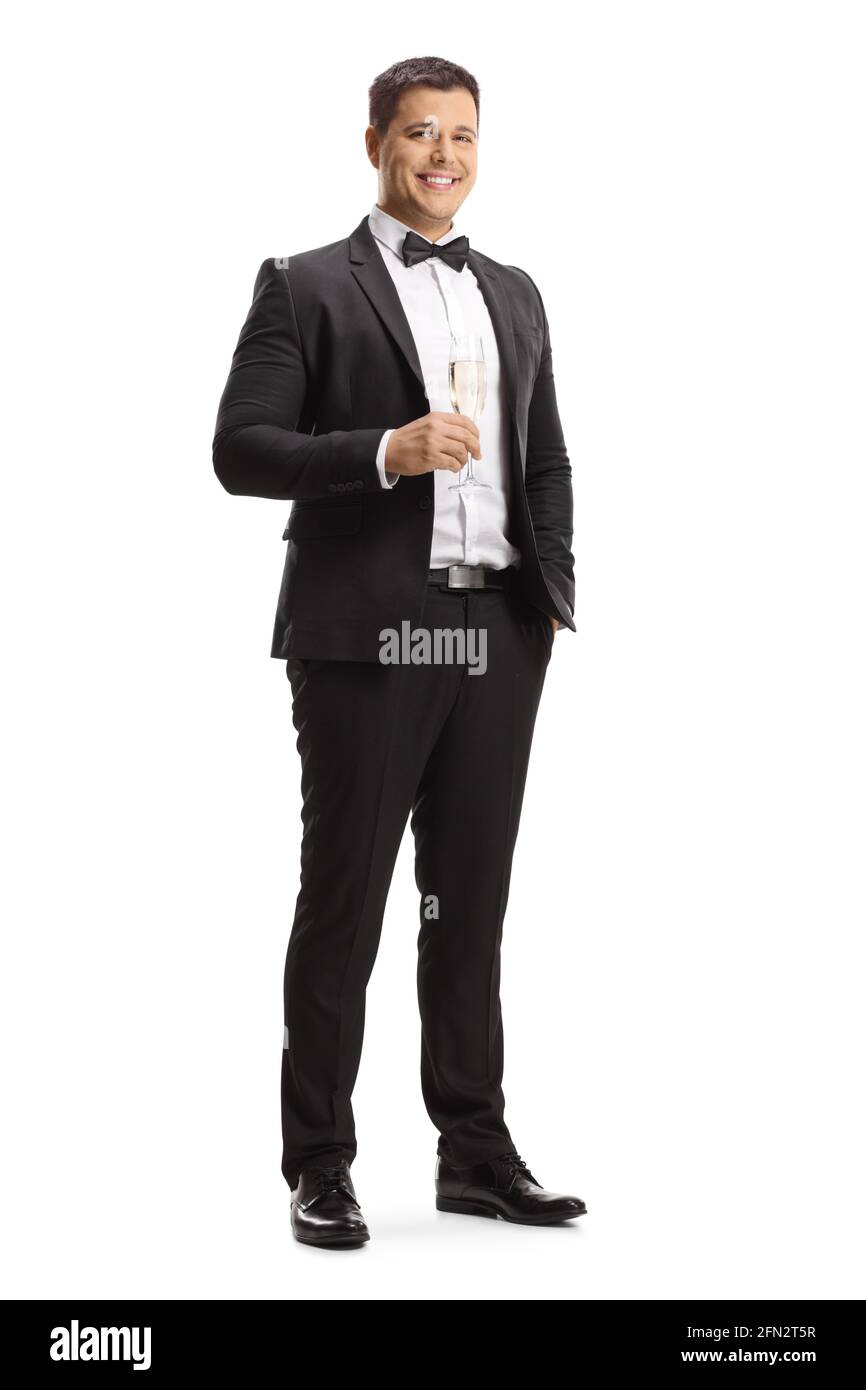 Elegante giovane uomo in tuta e con laccio a prua un bicchiere di spumante isolato su sfondo bianco Foto Stock