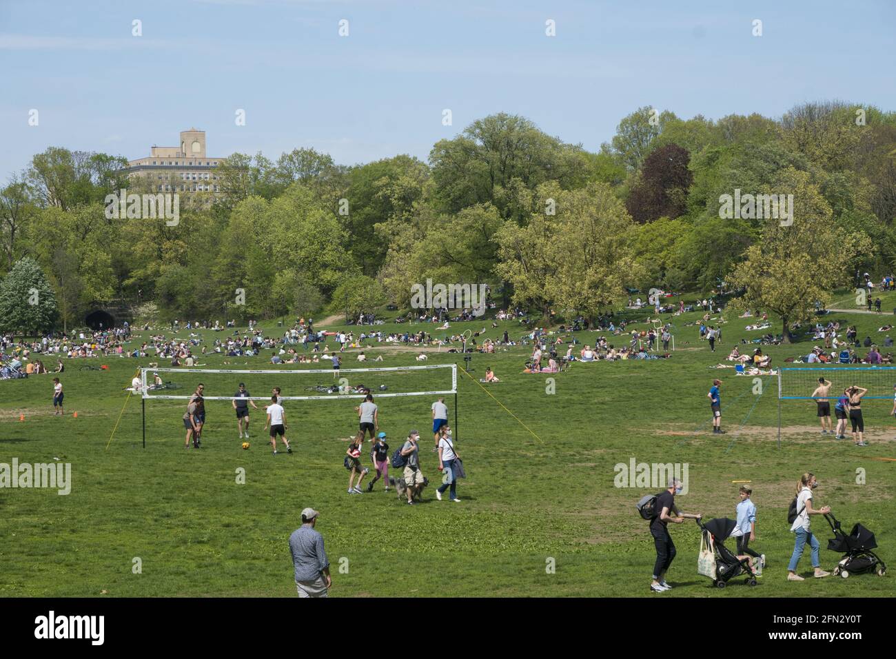 Gruppi di persone socialmente distanziati e godersi una calda giornata di primavera nel Prospect Park per oltre un anno nella pandemia Covid-19 a Brooklyn, New York. Foto Stock