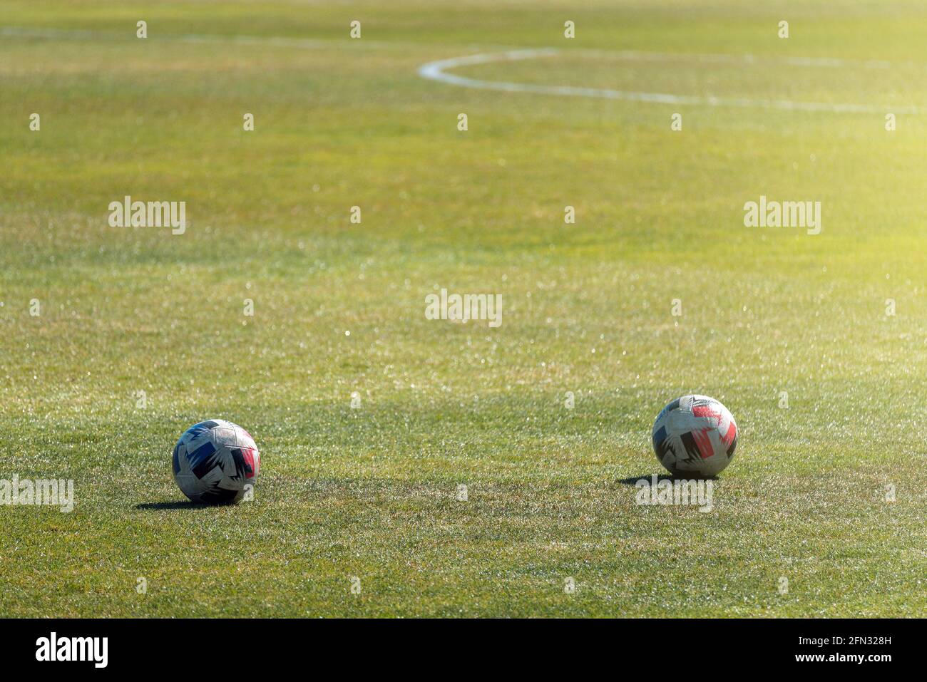 Due palle da calcio su un campo da gioco di erba sintetica Foto Stock