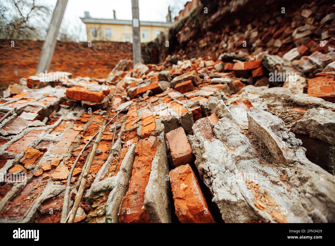 un muro di mattoni distrutto da un'esplosione. la guerra distrugge edifici storici. c'è stato un crollo della casa. le rovine della vecchia fortezza giacciono sul gr Foto Stock