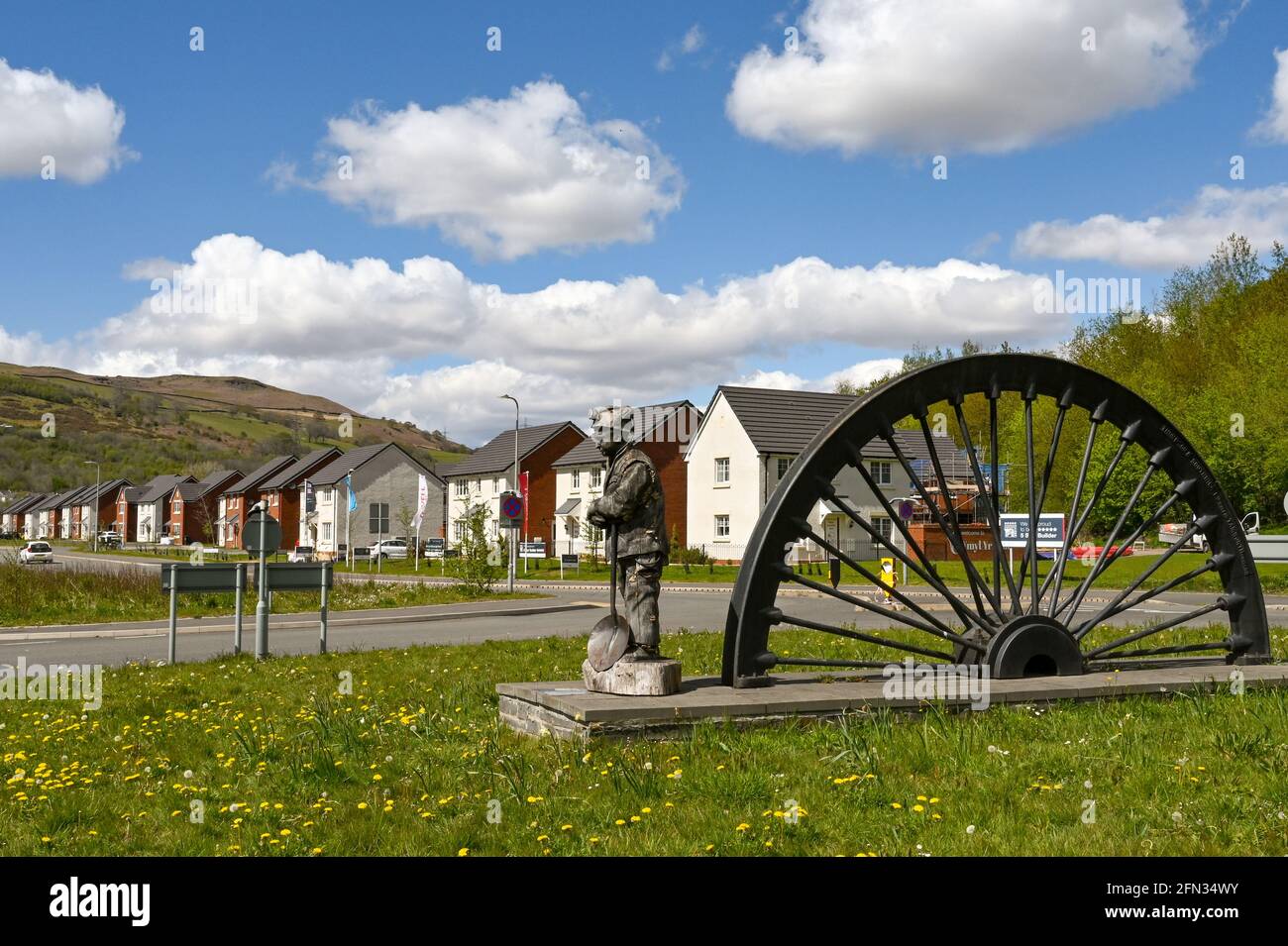 Merthyr vale, Galles - Maggio 2021: Vecchia ruota panoramica su una rotatoria all'ingresso di un nuovo edificio vicino a Merthyr Tydfil. Le case sono costruite o Foto Stock