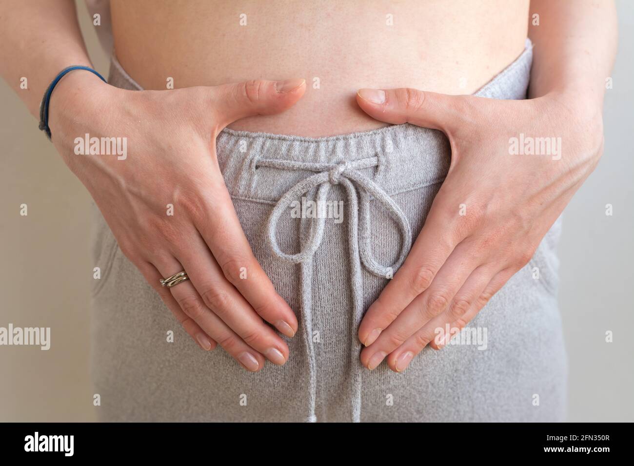 Donna incinta che tiene le mani sulla pancia da vicino. Concetto di  gravidanza Foto stock - Alamy