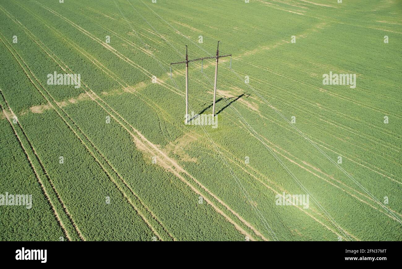 Controllare le linee elettriche con la vista dell'antenna del drone sul campo verde sfondo Foto Stock